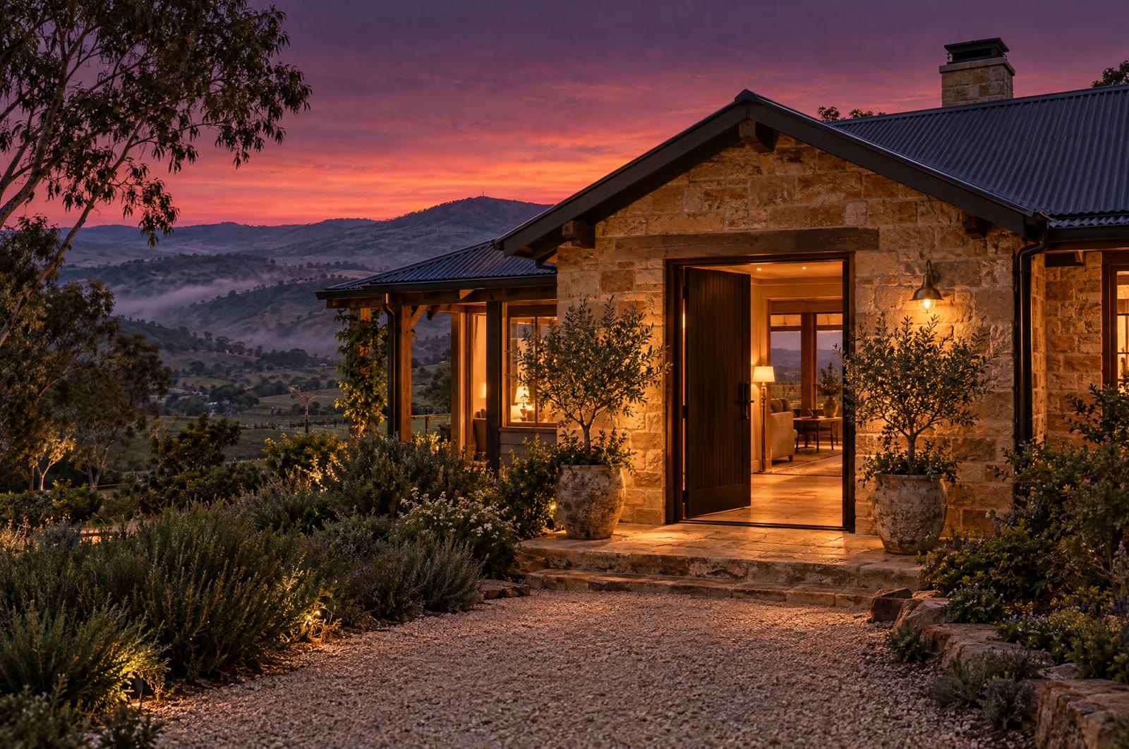 The open front door of a sandstone home in the Adelaide Hills at dusk, warm light spilling onto the step
